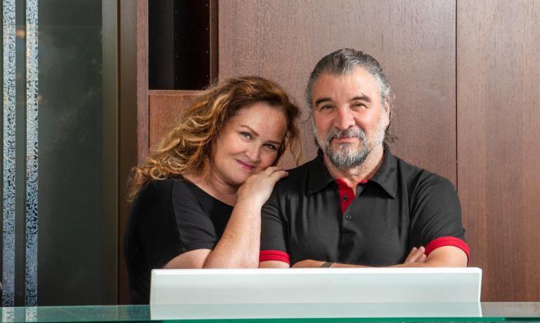 Smiling couple in front of a wooden counter.